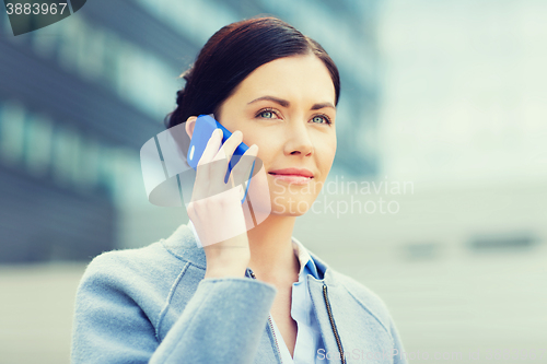 Image of young smiling businesswoman calling on smartphone