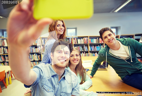 Image of students with smartphone taking selfie in library