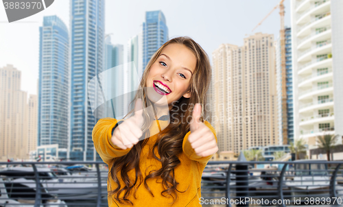 Image of happy young woman or teen girl showing thumbs up