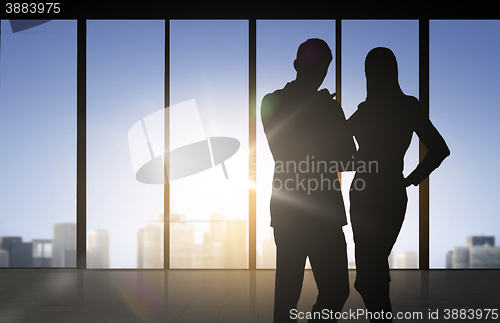 Image of silhouettes of business partners over office