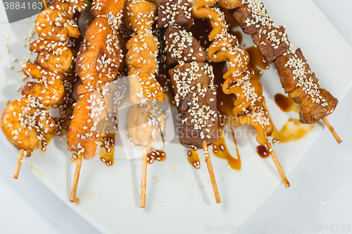 Image of Grilled juicy skewered shashlik on a plate, sesame