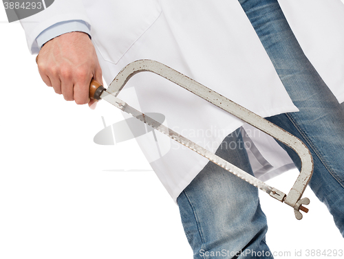 Image of Crazy doctor is holding a big saw in his hands