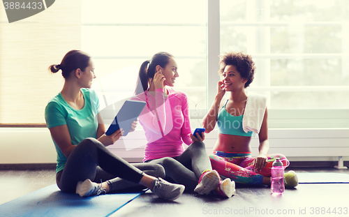 Image of happy women listening to music in gym