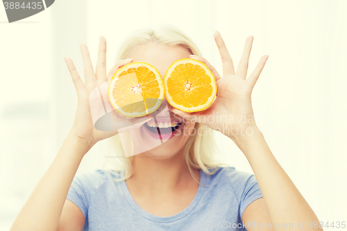 Image of happy woman having fun covering eyes with orange