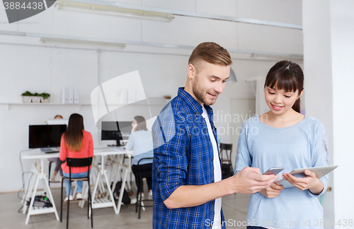 Image of couple with smartphone and tablet pc at office