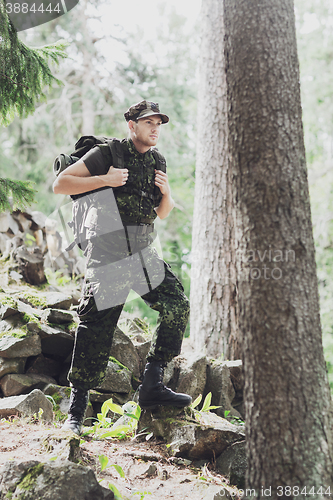 Image of young soldier with backpack in forest