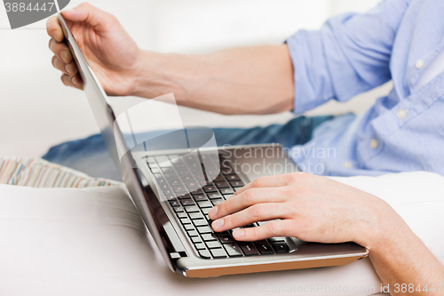 Image of close up of man typing on laptop computer at home