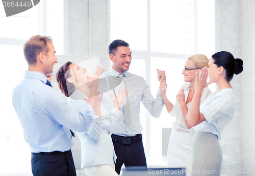 Image of business team celebrating victory in office