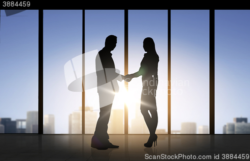 Image of business partners silhouettes shaking hands