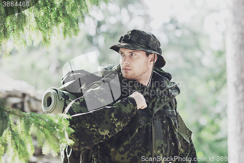 Image of young soldier with backpack in forest