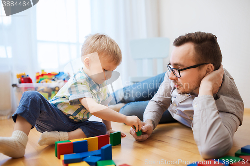 Image of father and son playing with toy blocks at home