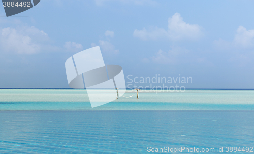 Image of hammock in water on maldives beach