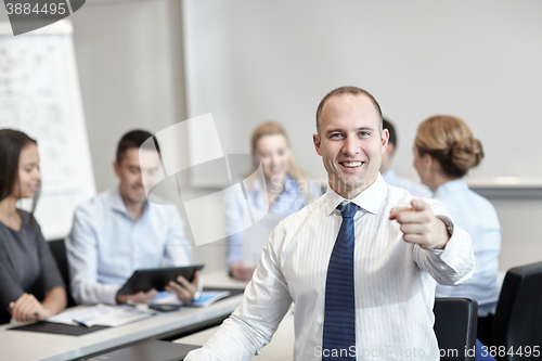 Image of group of smiling businesspeople meeting in office