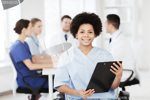 Image of happy doctor over group of medics at hospital