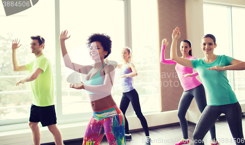 Image of group of smiling people dancing in gym or studio
