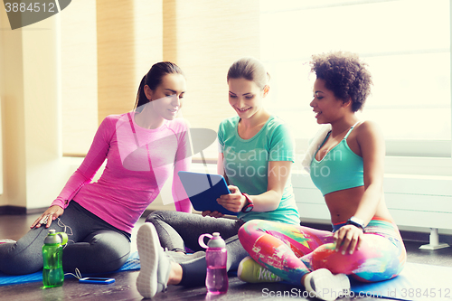 Image of group of happy women with tablet pc in gym