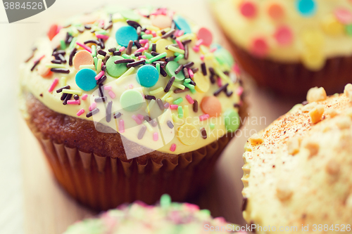 Image of close up of glazed cupcakes or muffins on table