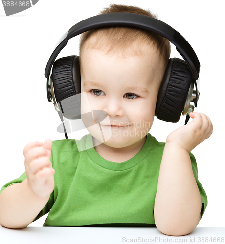 Image of Cute little boy enjoying music using headphones