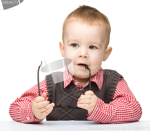 Image of Little child is biting glasses
