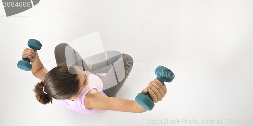Image of Young fit woman lifting dumbbells