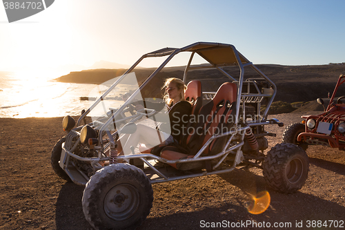 Image of Woman driving quadbike in sunset.