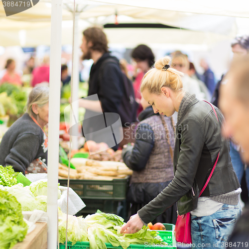 Image of Woman buying vegetable at local food market. 