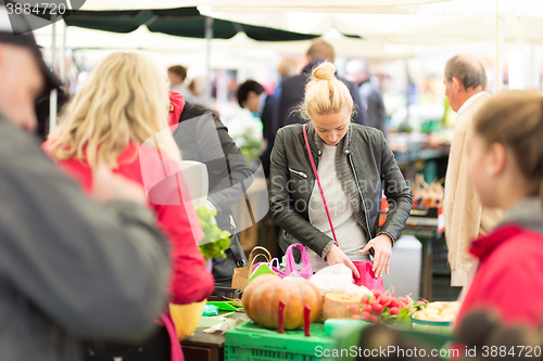 Image of Woman buying vegetable at local food market. 