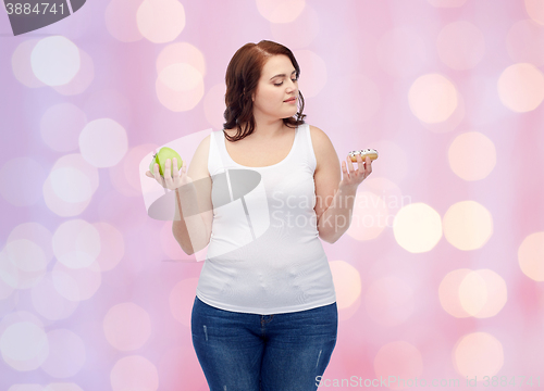 Image of young plus size woman choosing apple or cookie