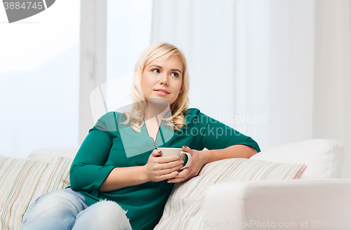 Image of happy woman  with cup of tea or coffee at home