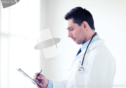 Image of male doctor with stethoscope writing prescription