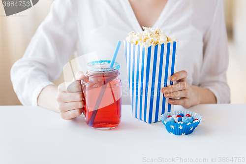 Image of woman with popcorn and drink in glass mason jar