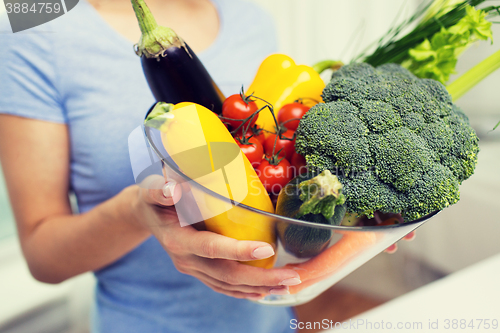 Image of close up of woman holding vegetables in bowl