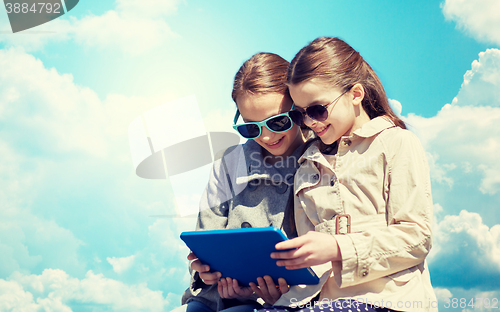 Image of happy girls with tablet pc computer over blue sky