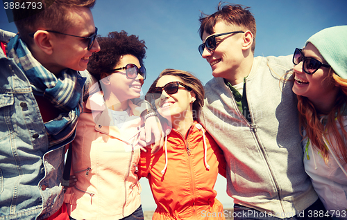 Image of smiling friends in sunglasses laughing on street