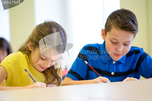 Image of group of school kids writing test in classroom