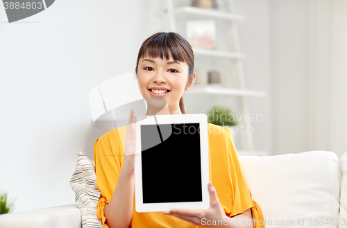 Image of happy young asian woman with tablet pc at home
