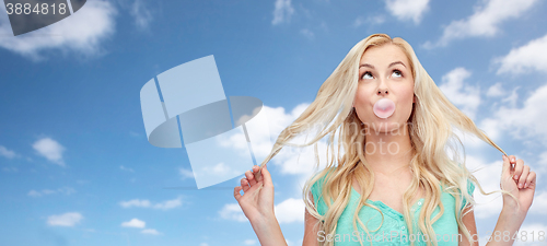 Image of happy young woman or teenage girl chewing gum