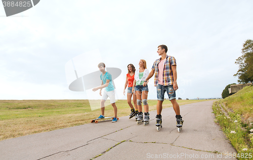 Image of happy teenagers with rollerskates and longboards