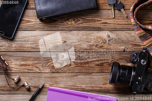 Image of Travel concept - headphones, camera,  sketchbook, purse, pencil and keys on wooden background.