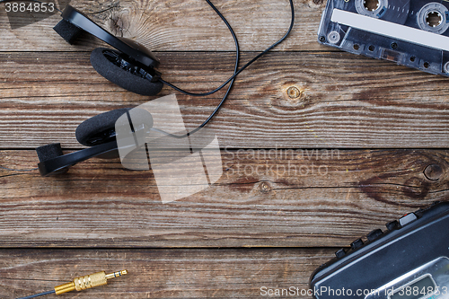 Image of Cassette tapes, cassette player and headphones over wooden table. top view.