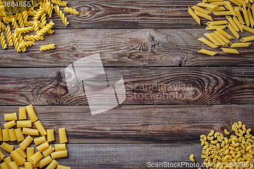 Image of Mixed dried pasta selection on wooden background.