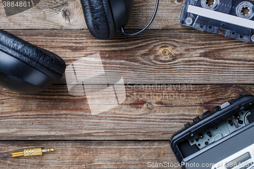 Image of Cassette tapes, cassette player and headphones over wooden table. top view.