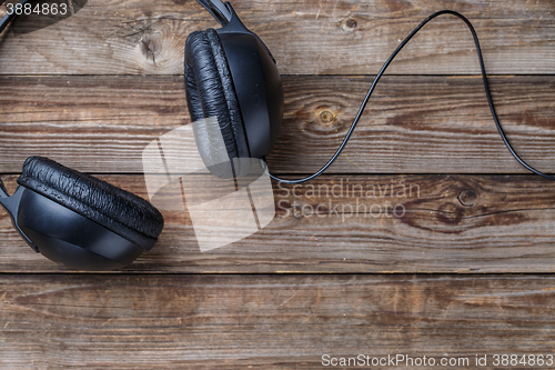 Image of Headphones over wooden table.