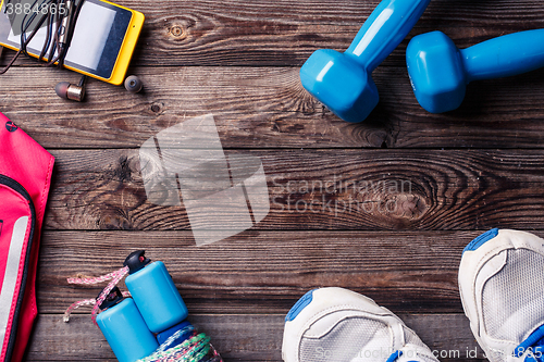 Image of Sports equipment - sneakers, skipping rope, dumbbells, smartphone and headphones. 