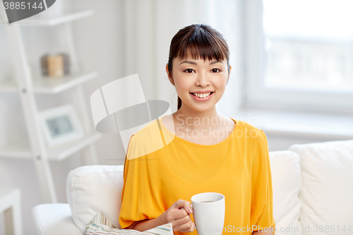 Image of happy asian woman drinking from tea cup