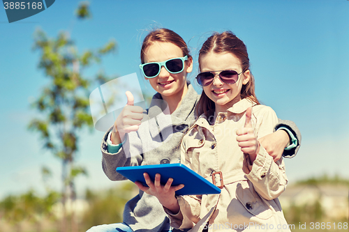 Image of happy girls with tablet pc showing thumbs up