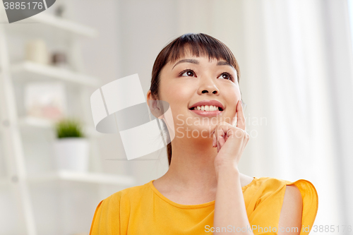 Image of happy asian young dreaming woman face at home
