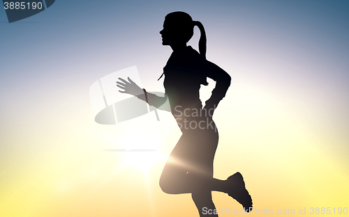 Image of happy young sports woman running outdoors