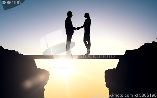 Image of business partners silhouettes shaking hands