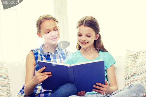 Image of two happy girls reading book at home